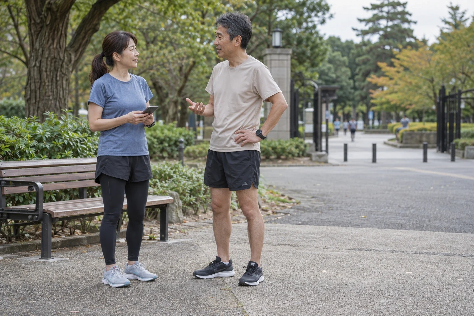 公園のベンチ脇で走る前の相談をする2人